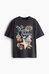 Remera negra de corte amplio con estampado del logo de la banda The Smashing Pumpkins, ángeles, flores y un sol.