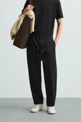 Pantalón verde militar de corte carrot fit, confeccionado en tejido de algodón. Cuenta con cintura elástica ajustable con cordón, bolsillos frontales y un bolsillo trasero de plastrón.