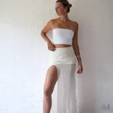 Pollera larga de microtul color crudo, con cintura alta fruncida y abertura lateral.