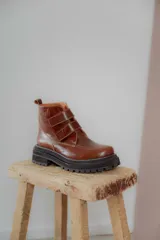 Botas cortas de cuero color hueso, con puntera redondeada, ajuste con doble tira con velcro color verde oliva y suela track color negro.