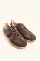 Zapatillas bajas de cuero color crudo con detalles en gamuza color beige y suela de goma color caramelo.