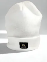 Gorro de lana blanco con dobladillo y etiqueta negra con logo de Alquimia.