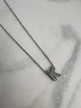 Collar de cadena fina plateada con dije de la letra "F" incrustada con strass.