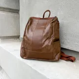 Mochila marrón de eco-cuero con cierre superior y correas ajustables.