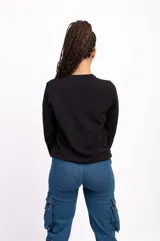 Buzo negro de algodón de corte clásico con cuello redondo y mangas largas. Tiene un pequeño logo bordado en el pecho.