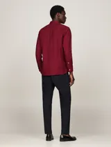 Camisa de manga larga color rojo con cuello abotonado y logo de Tommy Hilfiger bordado en el pecho.