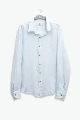 Camisa celeste de lino con botones de coco y corte recto.