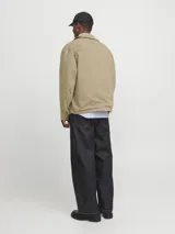 Sobrecamisa shacket color beige con cierre de cremallera y diseño resistente. Confeccionada en tejido liviano, delgado y transpirable de poliéster reciclado. Presenta cuello clásico, mangas largas con puños abotonados, cierre con cremallera y bolsillos frontales funcionales.