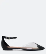 Zapatilla baja negra con puntera fina, laterales transparentes y cierre con hebilla en el tobillo.