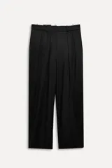 Pantalón negro de tiro alto con trabillas, bolsillos laterales y falsos bolsillos de vivo con solapa en la espalda. Detalle de cinturilla interior a contraste con pespuntes. Pinzas en el delantero. Cierre frontal con cremallera, botón interior y gancho metálico.