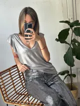Blusa dorada con escote en V y mangas cortas con volados.