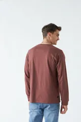 Remera gris de manga larga con cuello redondo y logo bordado en el pecho.