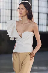Pantalón de vestir color arena, de tiro medio y corte recto, confeccionado en hilatura con viscosa. Cuenta con bolsillos laterales, raya planchada en delantero y cierre frontal con cremallera, botón y gancho metálico.