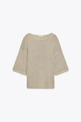 Top color beige de tejido de punto, con cuello redondo y mangas cortas tipo capa.
