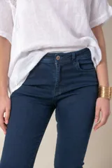 Pantalón de jean azul de tiro alto con lycra, corte ajustado y ruedo doblado.