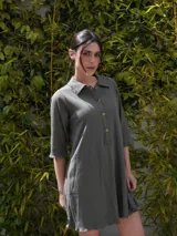 Vestido camisero verde seco de corte holgado, con cuello camisero, mangas 3/4 y cierre frontal con botones.