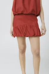 Minifalda color ladrillo con cintura alta y volados en el ruedo.