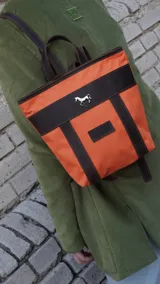 Mochila pequeña color borgoña con detalles en cuero marrón, asa de mano y correas ajustables.