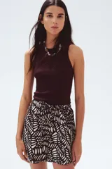 Short marrón con estampado de hojas blancas, cintura elástica con cordón ajustable y bolsillos laterales.