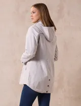 Campera impermeable color gris claro, marca Gallery. Tiene abertura central con cierre oculto y botones a presión, bolsillos delanteros y capucha plegable en el cuello.