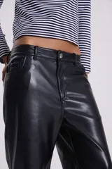 Pantalón recto de cuero sintético negro, estilo jeanero con tiro bajo, bolsillos delanteros y traseros, pretina con botón y pasacintos.