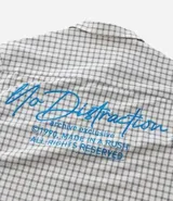 Camisa de hombre de manga corta, cuello inglés y corte boxy, confeccionada en algodón tricolina texturizada a cuadros. Presenta abotonado frontal y bordado en la espalda.