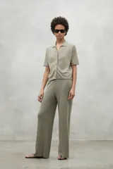 Pantalón de lino color verde oliva, de corte holgado con pierna ancha y cintura elástica.