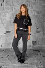 Remera de algodón negra, de corte recto y estilo relajado. Presenta un diseño moderno con vivos en plateado metálico en el escote redondo, el borde inferior y el bolsillo delantero, que le aportan un toque urbano y sofisticado.