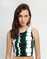 Top corto con estampado geométrico en verde, blanco y negro, de cuello redondo y corte halter. Presenta cierre lateral y abertura con botón en la espalda.
