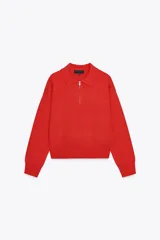 Sweater rojo de punto con cuello polo y cierre frontal con cremallera metálica.