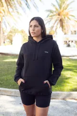 Canguro negro con capucha y cordones ajustables, bolsillo tipo canguro y logo pequeño en el pecho.