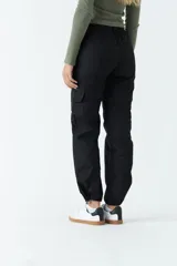 Pantalón cargo negro de tiro medio con cintura elastizada, bolsillos laterales y ajuste en los tobillos.