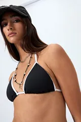 Top de bikini triangular negro con bordes blancos y tirantes finos.