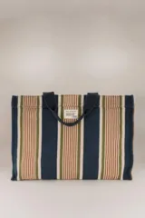 Bolso tote de algodón con rayas verticales en azul, verde, marrón y blanco. Tiene doble asa corta color azul marino y un bolsillo interior.