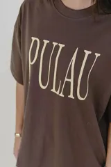 Remera verde con estampado de la palabra "Pulau" en color lila.