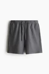 Short gris oscuro de lino y algodón, corte relaxed fit, con cintura elastizada ajustable con cordón, bolsillos laterales y bolsillo trasero.