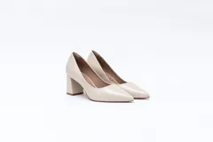 Zapato de tacón color beige, de cuero charol, con punta fina y taco cuadrado.