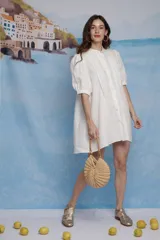 Vestido corto blanco de lino, con cuello mao, tablillas frontales y mangas balloon a la altura del codo.