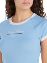 Remera celeste de algodón con corte slim, cuello redondo y mangas raglán con ribetes blancos. Estampado frontal con el logo de Tommy Hilfiger.