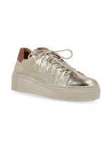 Sneaker de cuero graneado color plateado con detalles en color cobre en la puntera y el talón. Tiene suela elevada color hueso y cordones de algodón.