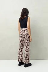 Pantalón de corte recto con estampado botánico en tonos blanco, negro y bordó.