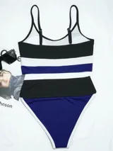 Conjunto de bikini con corpiño deportivo de breteles finos y bombacha tiro alto con elástico ancho. Diseño a rayas horizontales en negro, blanco y azul.