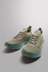 Zapatillas deportivas color beige con suela celeste, para uso diario y carreras ligeras. Parte superior de tejido de punto transpirable, puntera y talón recubiertos de material Shield Protect Max, ajuste con cordones, tirador trasero, plantilla OrthoLite
 y entresuela con tecnología Spume Foam V2.