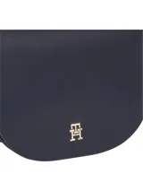 Cartera saddle Tommy Hilfiger color azul marino, con correa bandolera de tela con el logo de la marca en azul y blanco. Tiene cierre de solapa con broche magnético y el logo de la marca en dorado en el frente.