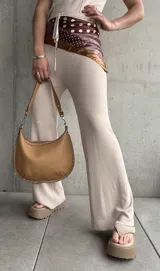 Pantalón acampanado color beige de tejido de punto acanalado.