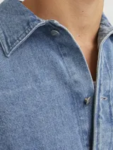 Sobrecamisa de jean celeste con manga larga, cuello clásico, cierre con botones y bolsillo frontal.