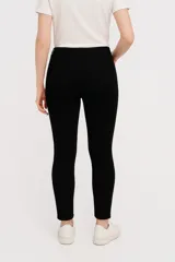Pantalón skinny color marfil, tiro medio, con bolsillos delanteros y traseros.