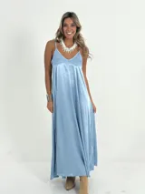 Vestido italiano amplio con escote en V, confeccionado en tela nacarada con cuerpo que aporta estructura y movimiento.
