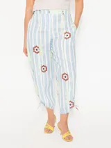 Pantalón de lino liviano con estampado de rayas verticales y flores. Tiene un fit relajado y largo modular ajustable con jaretas laterales.