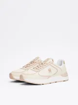 Zapatillas Tommy Hilfiger color beige con detalles en dorado. Confeccionadas en piel con monograma TH en la lengüeta y lateral. Suela de goma blanca y beige.
